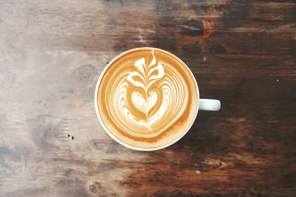 A latte with a heart pattern on a wooden table