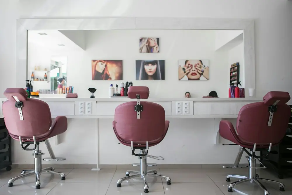 Bright salon with white styling chairs and mirrors