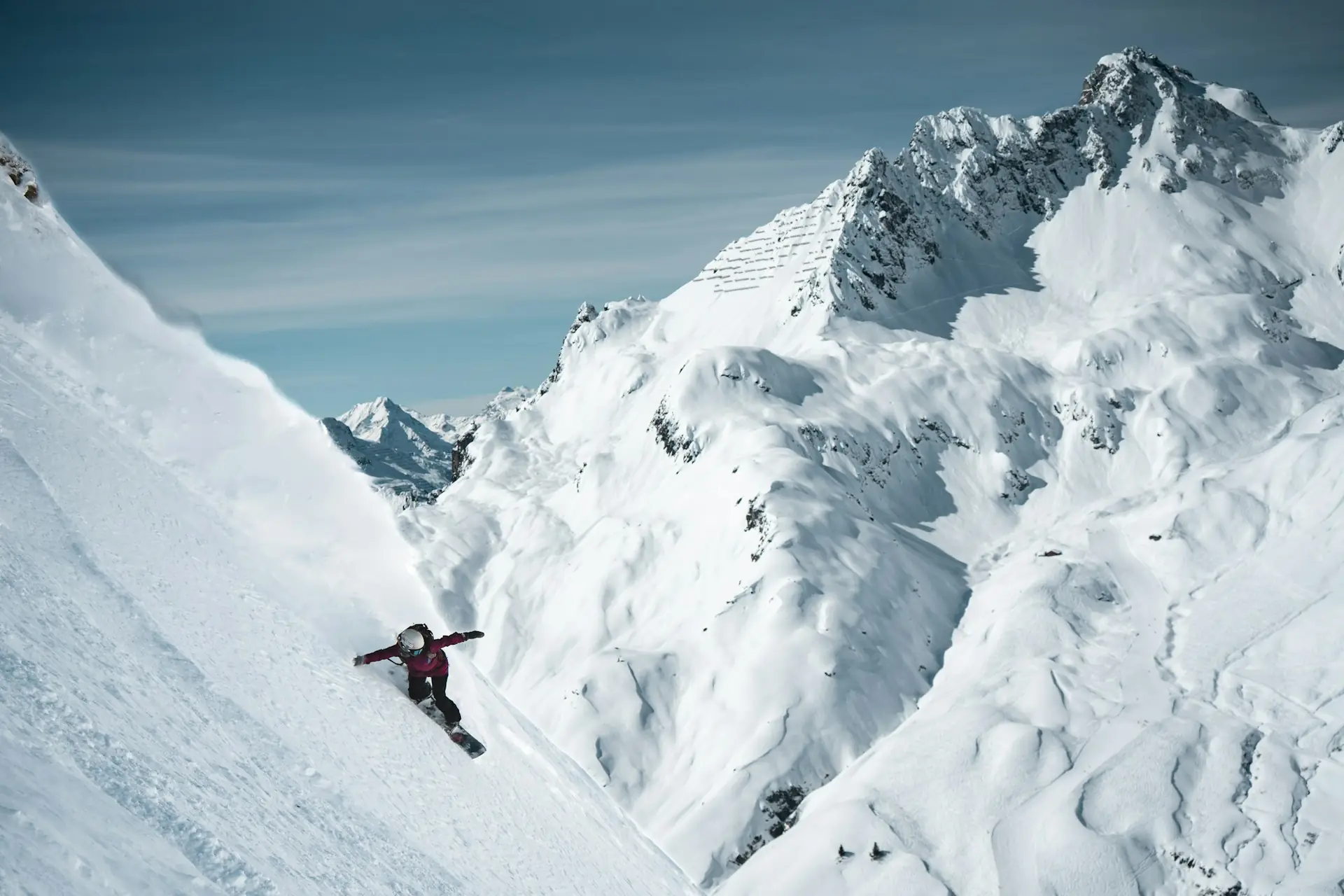 A skier carving through fresh powder, throwing a spray of snow