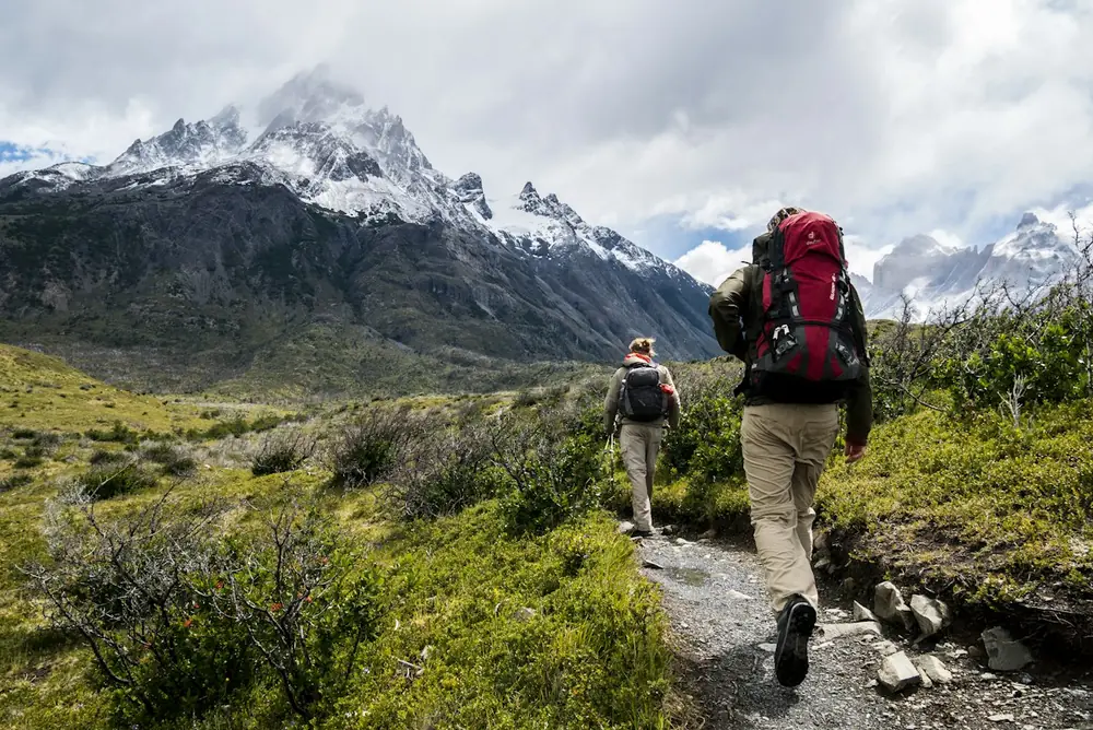 Hikers on a trail above an alpine lake